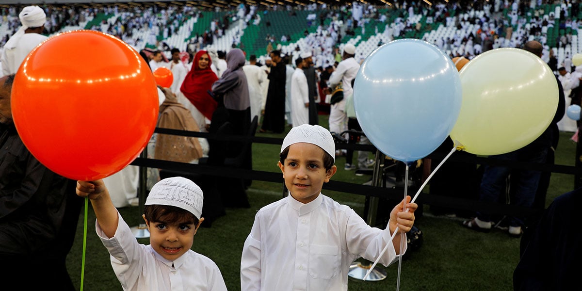 Children hold balloons while people come together to attend the prayer of the Aid Ul Fitr at the Stadium of Education, in Al Rayyan, Qatar, March 30, 2025. - Reuters