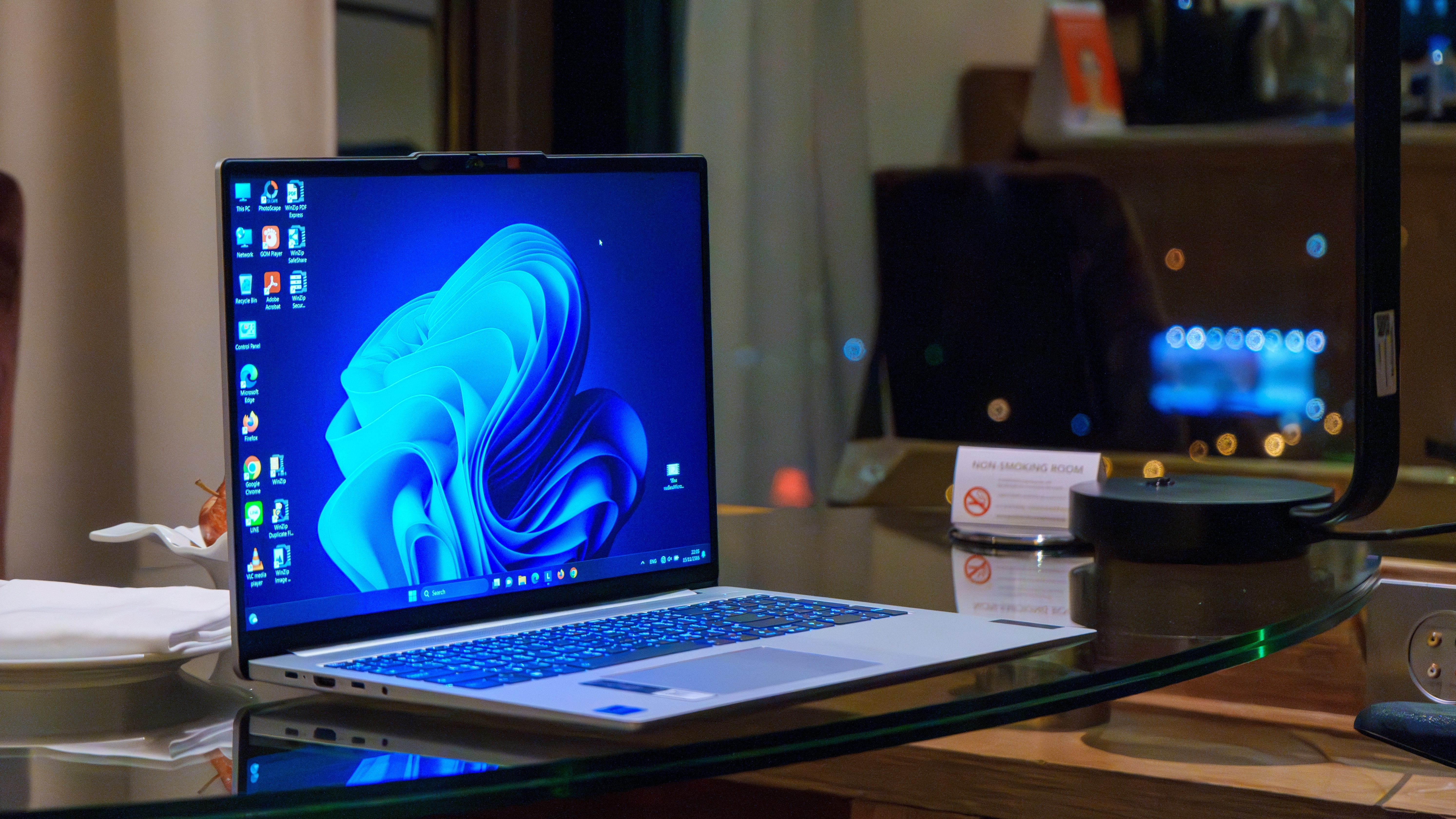 A laptop with the Windows 11 desktop on the screen, shiny, on a desk
