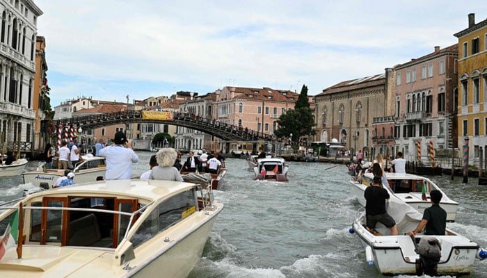 The Boat Moa carrying the founder of Amazons, Jeff Bezos, is escorted on the Grand Canal on his wedding day in Venice on June 27, 2025. - AFP