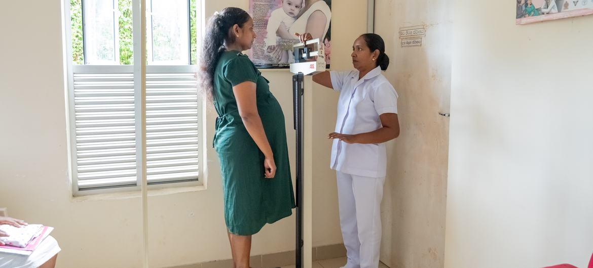 A nurse checks the weight of a pregnant woman and the vital signs in a clinic in Galigamuwa, Sri Lanka. A nurse checks the weight of a pregnant woman and the vital signs in a clinic in Galigamuwa, Sri Lanka.