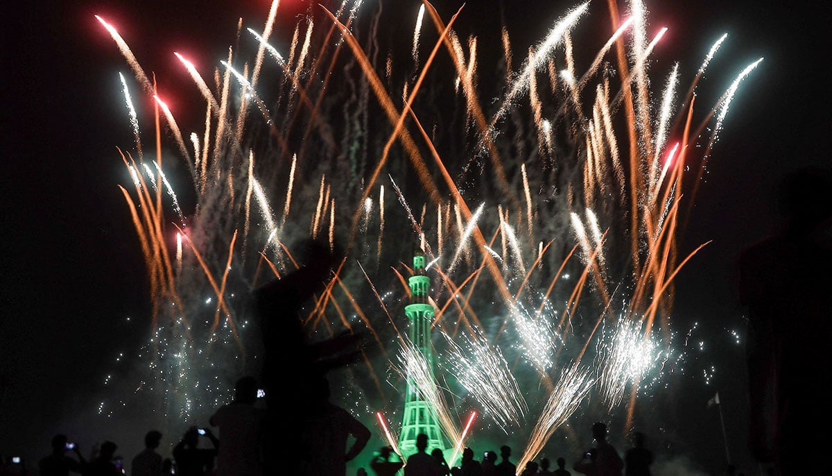 People watch fireworks explode on the monument of Minar-E-Pakistan illuminated during the celebration of independence in Lahore on August 14, 2025.-Reuters