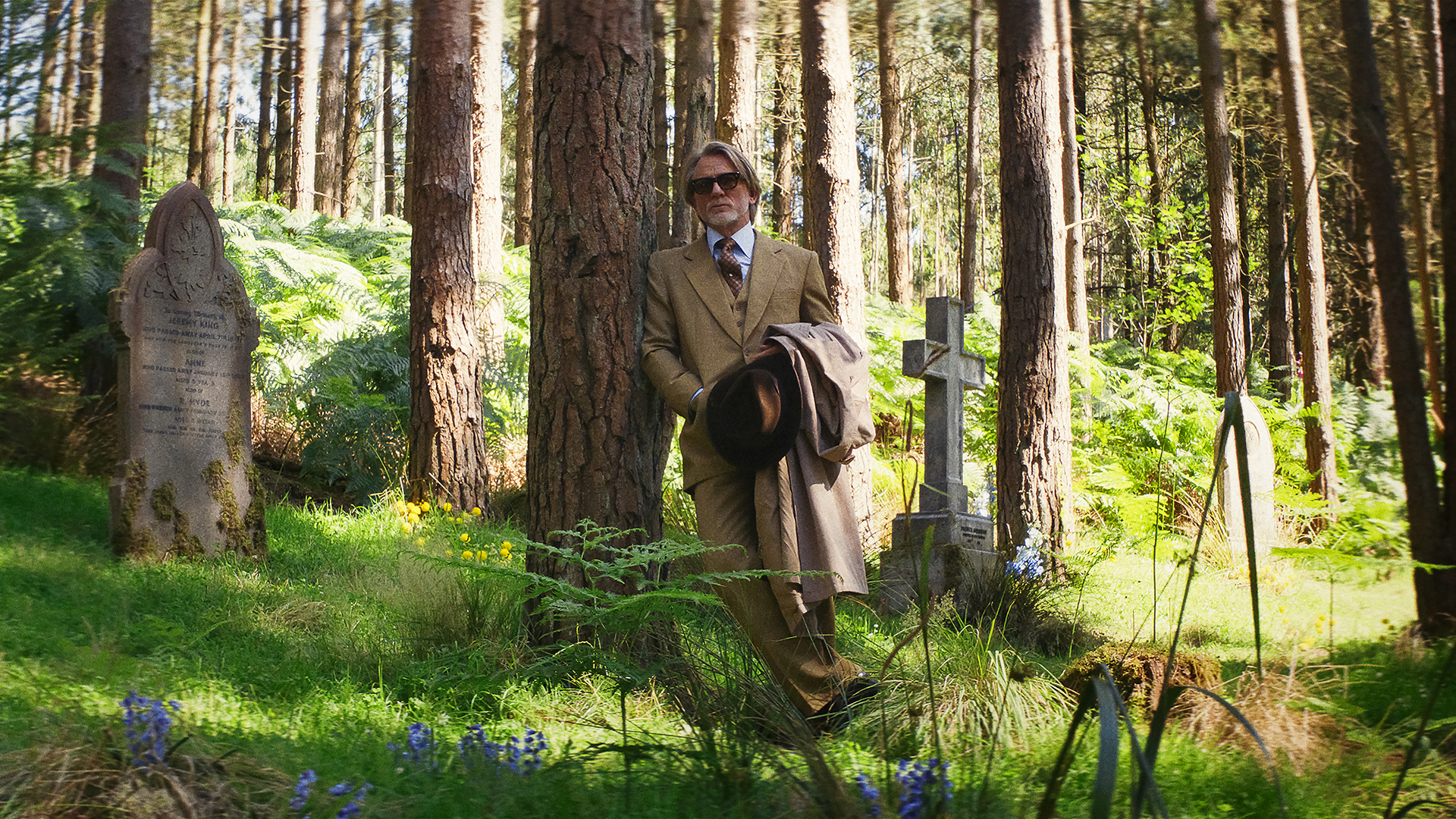 Benoit Blanc leaning against a tree in Wake Up Dead Man: A Knives Out Mystery