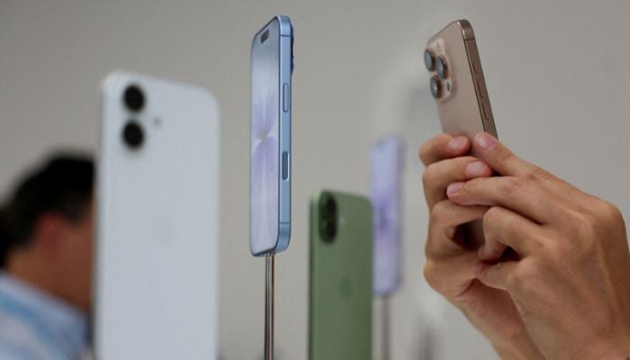 A person uses a phone to capture iPhones on display during the apple event at Steve Jobs Theater in Cupertino, California, United States, September 9, 2025. - Reuters