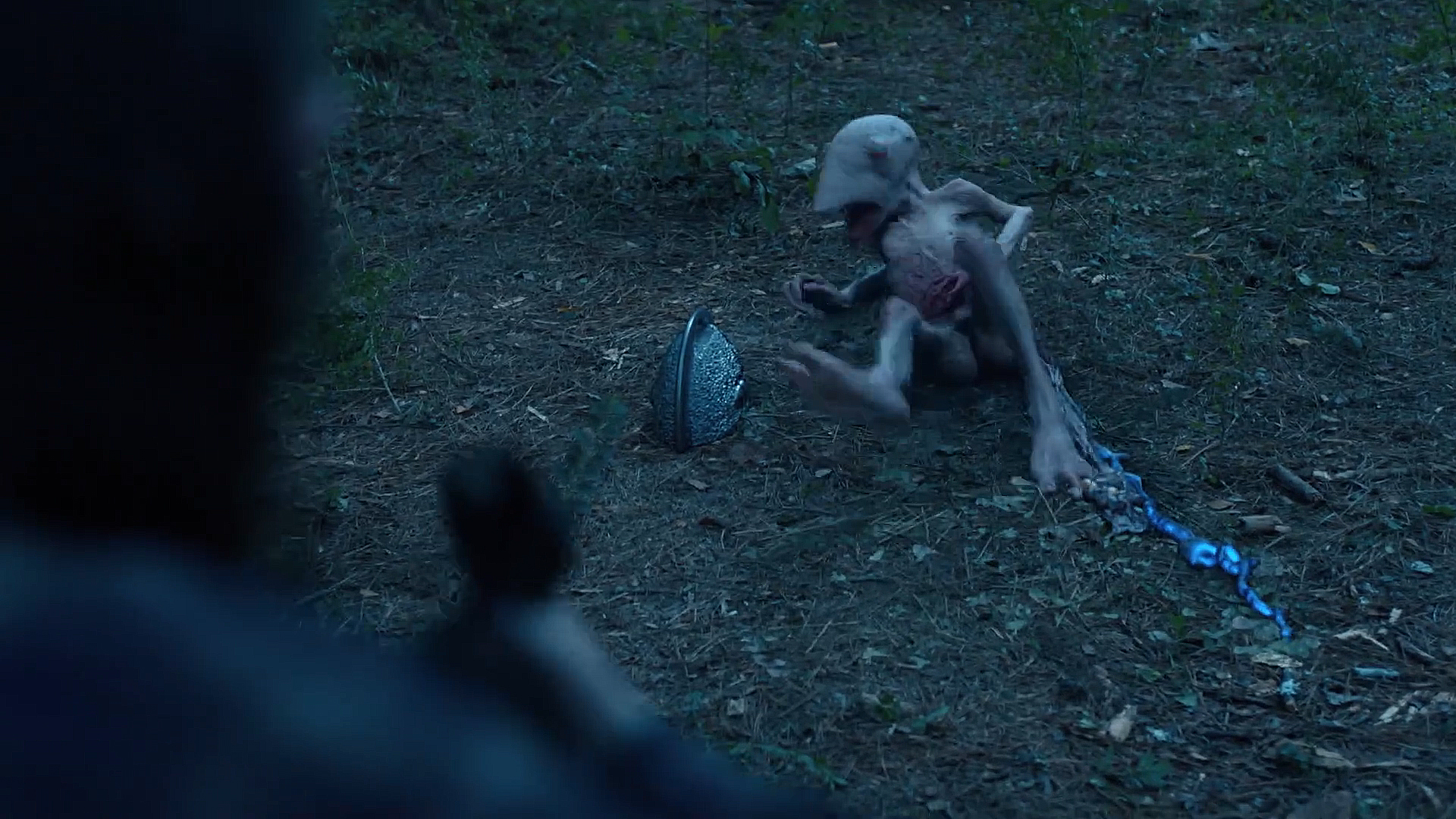 A stranger lying seriously injured on the forest floor with a silver housing sitting next to season 2 of season 2 episode 4