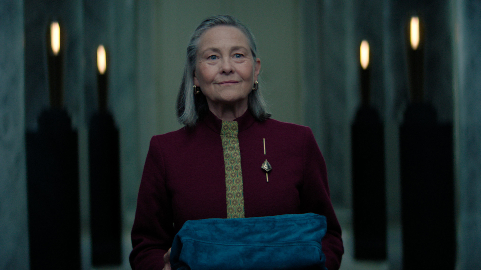 Quent ambassador holding an object covered with fabric in the season 3 episode 10 foundation