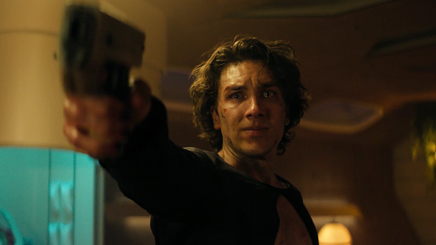 A Toran Mallow with tearful eyes brandishing a handgun in the foundation season 3 Episode 7
