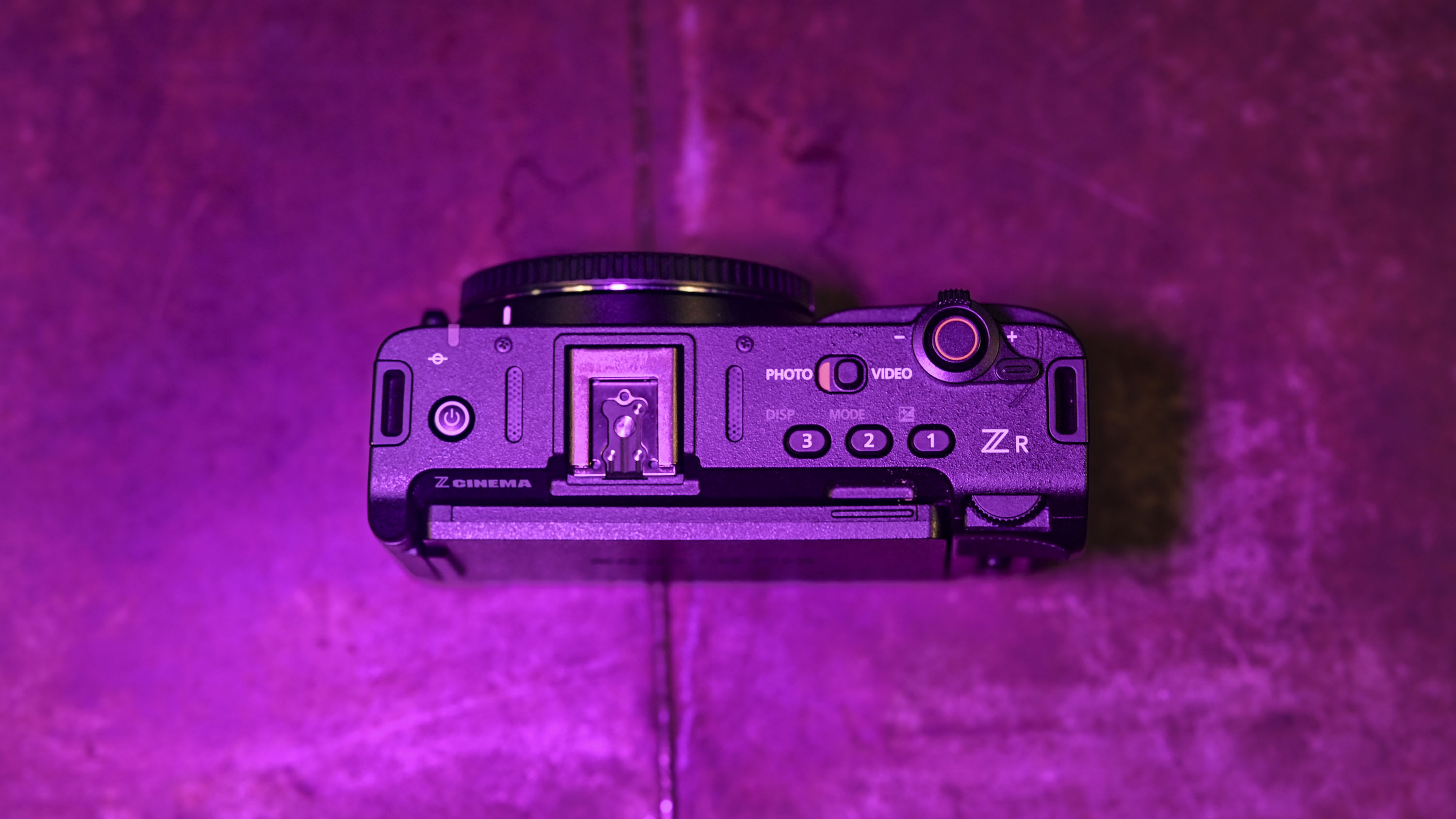 At the top of the Nikon ZR camera under discreet magenta lighting