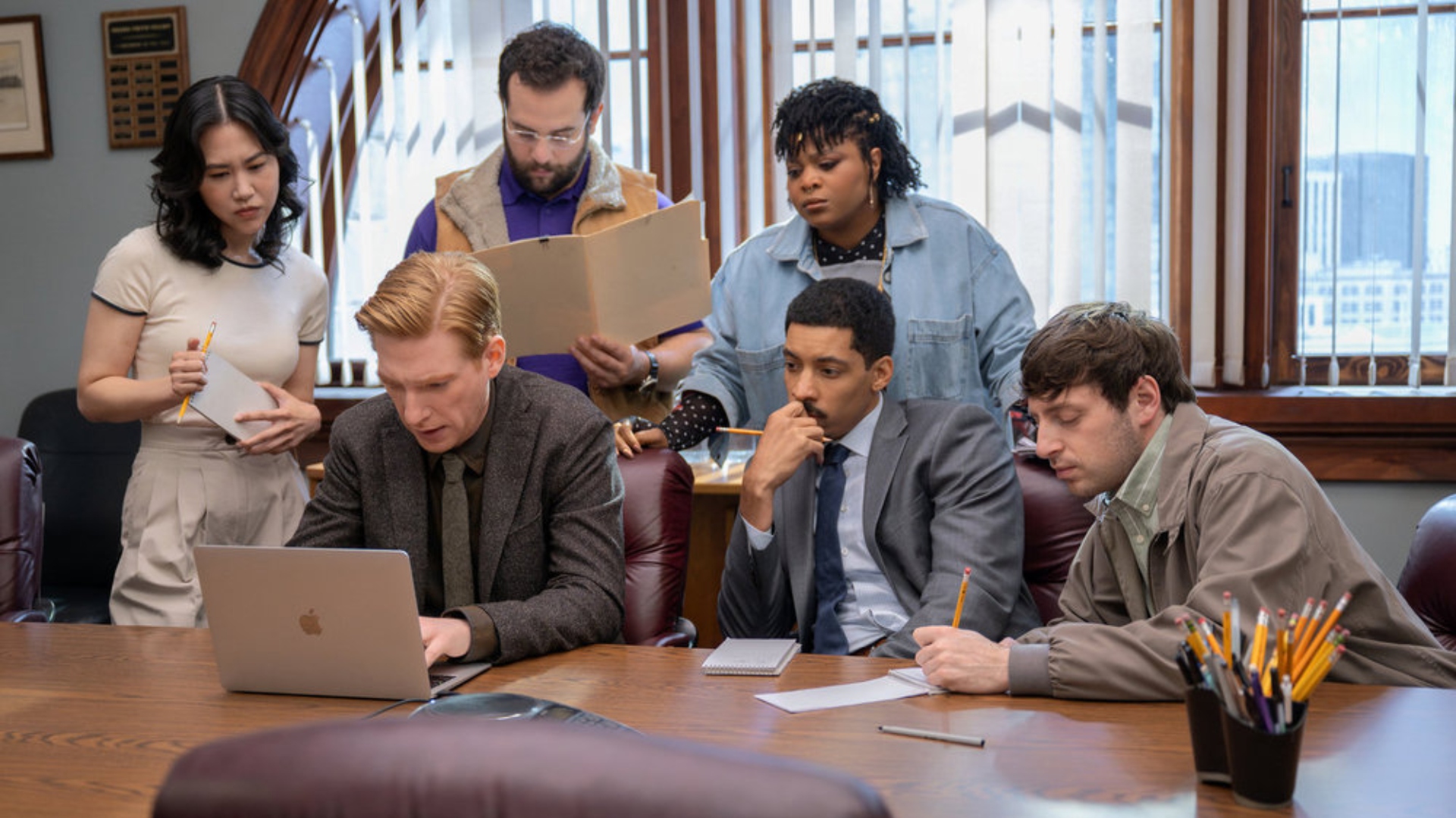 The staff are gathering around a laptop in season 1 of paper