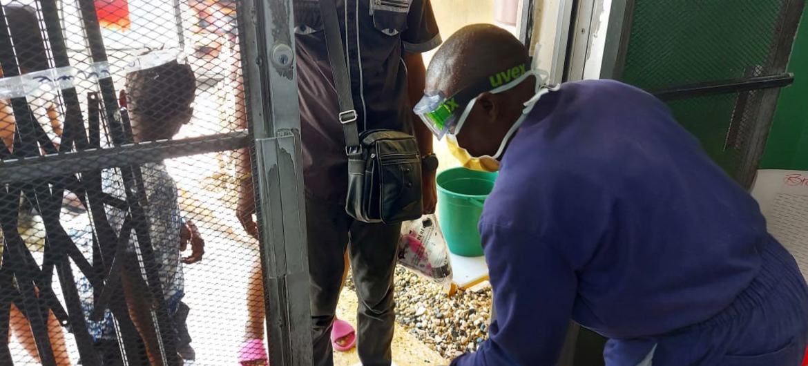A health worker performs sanitation procedures when people enter a cholera establishment in Haiti.