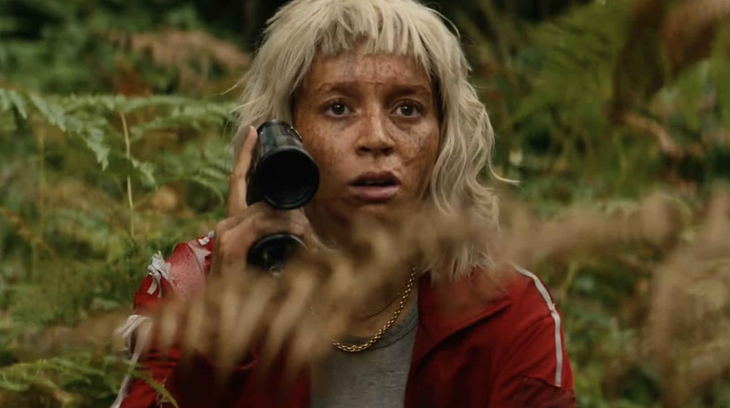 Alfie Williams like Spike, wearing a blonde wig and a red tracksuit
