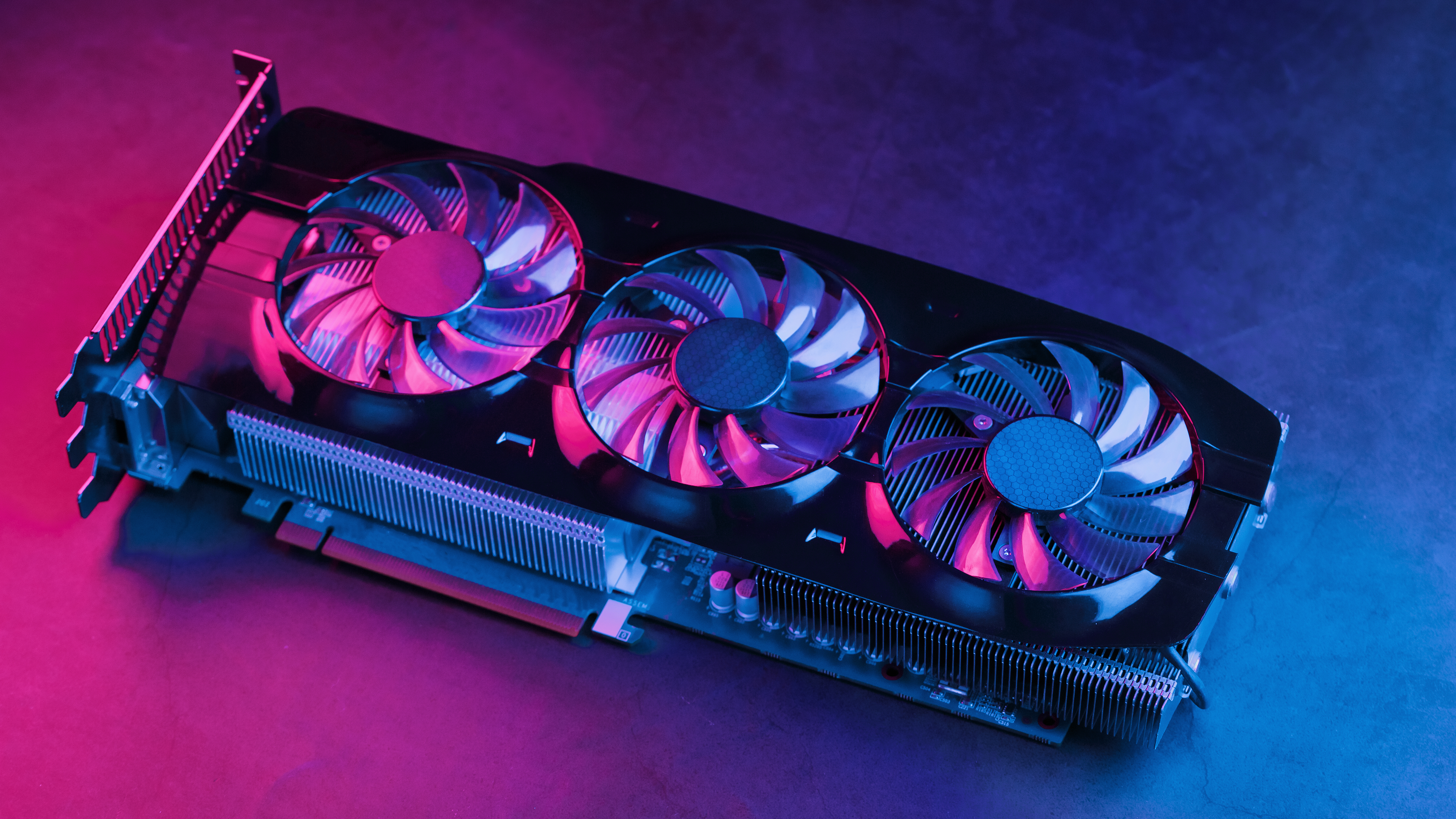 A graphics card on a pink and blue lighting table
