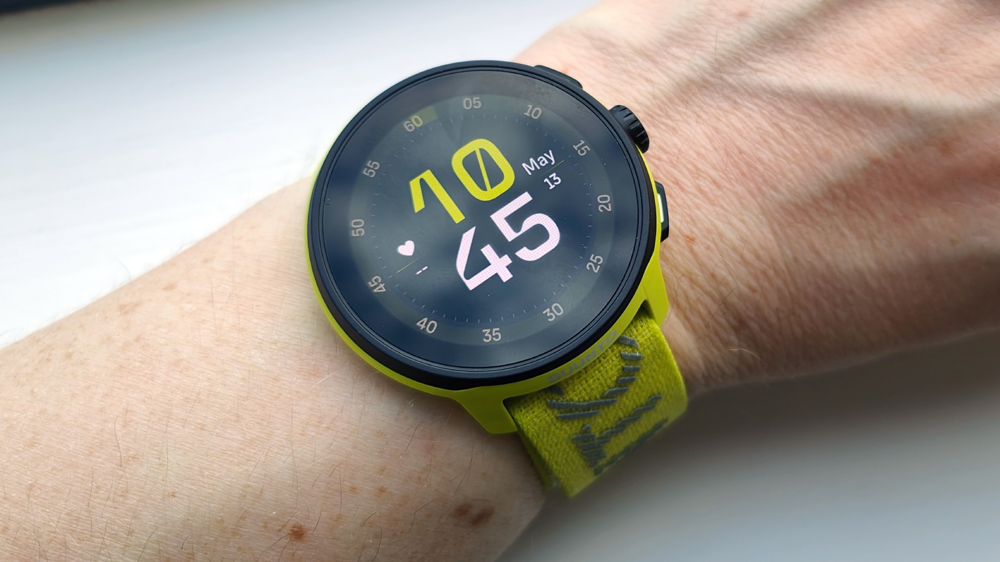Wrist with a yellow suunto race