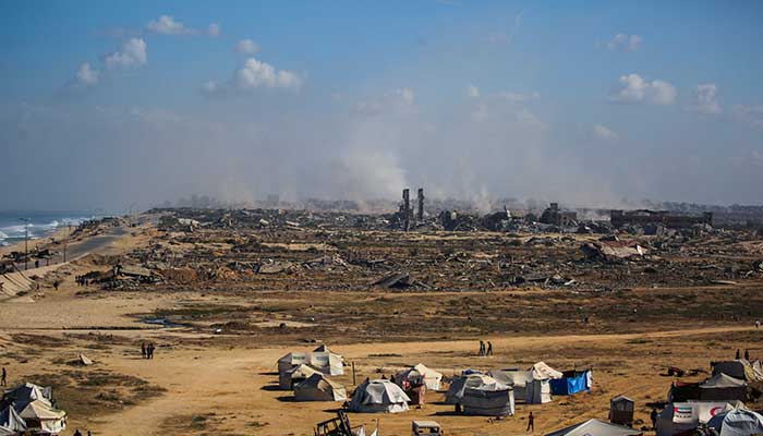 Palestinians walk around tents in Nuseirat, in the central Gaza Strip, on October 10, 2025. — AFP