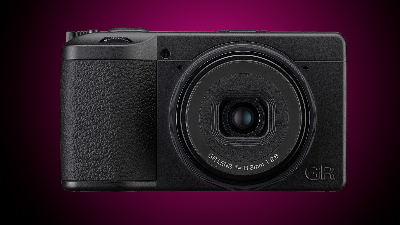 A Ricoh compact camera on a gradient purple background