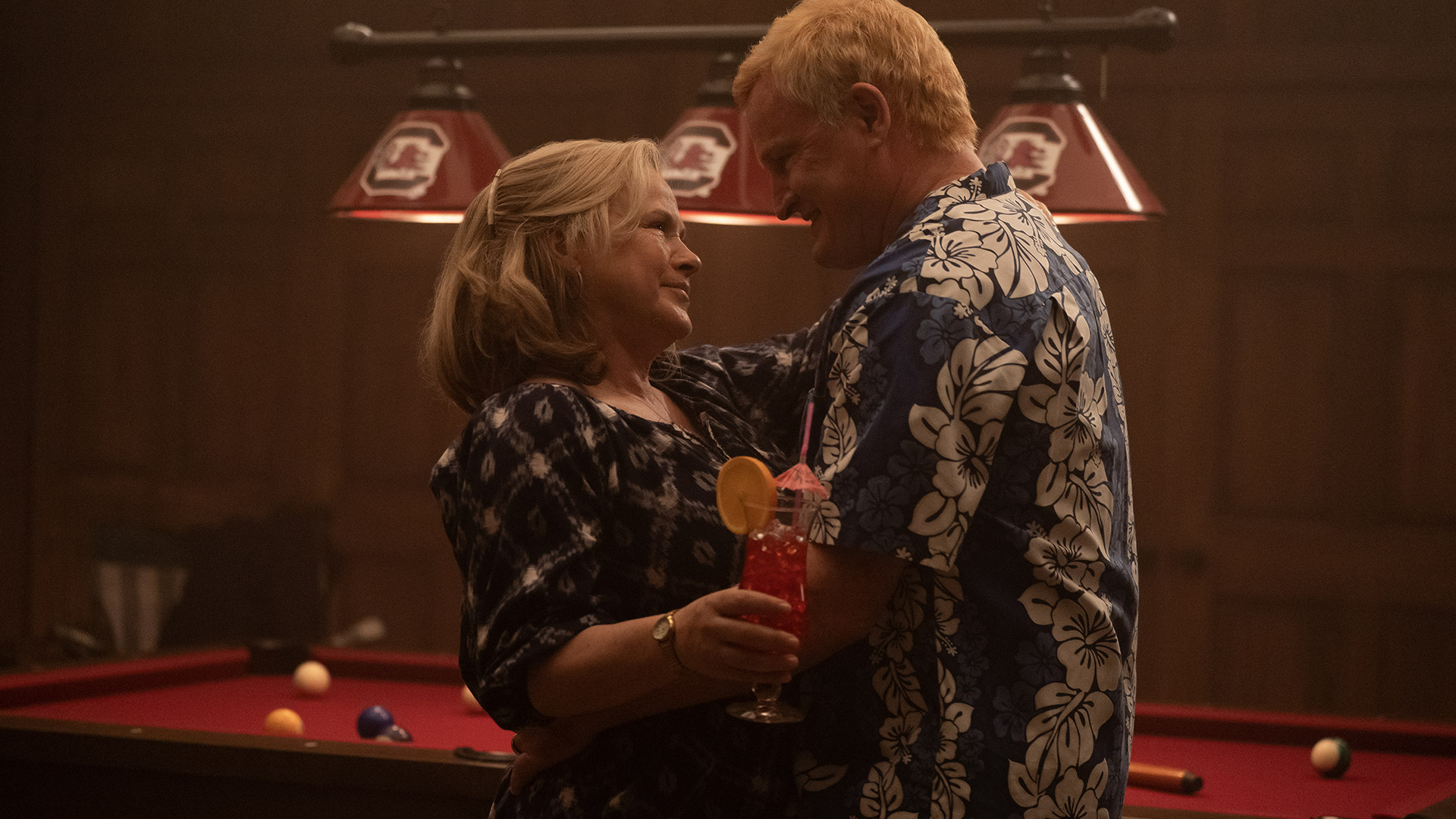 Patricia Arquette and Jason Clarke kiss in front of a pool table in Murdaugh: Death in the Family