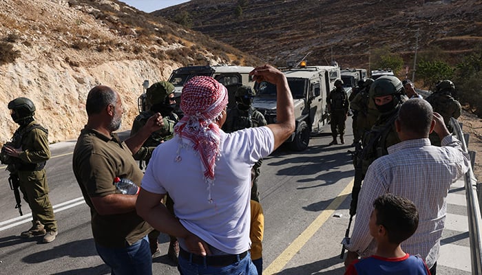 Palestinian farmers argue with Israeli security forces after their crops were disrupted by Israeli settlers and interrupted by Israeli security forces in the village of Sair, near the Israeli-occupied West Bank city of Hebron, October 23, 2025. — AFP
