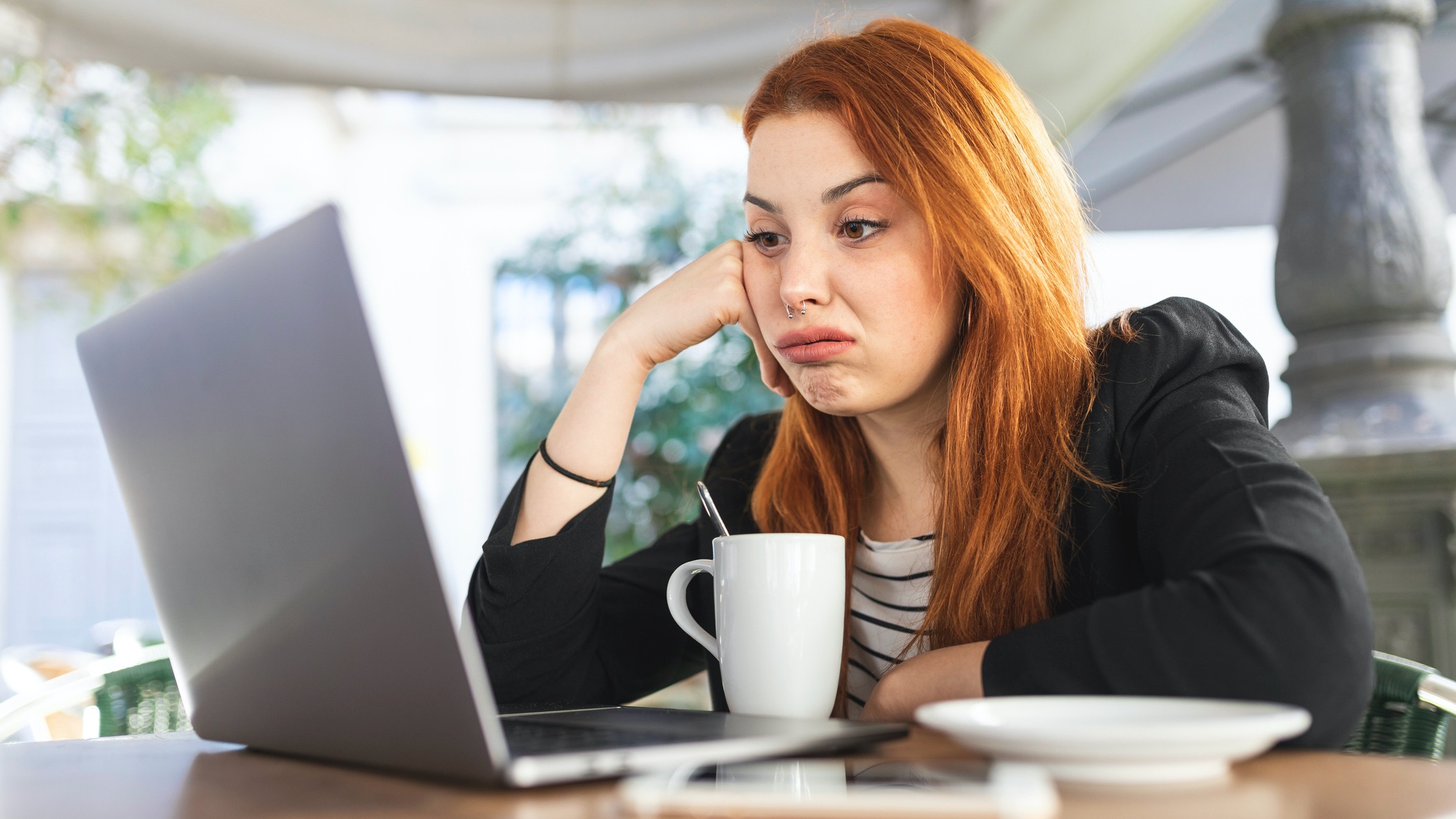 Young woman using laptop, looking bored