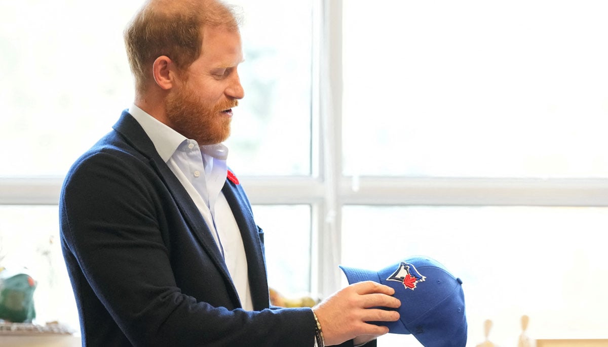 Prince Harry receives a Toronto Blue Jays hat as he meets with some of Canada's longest serving veterans, at the Sunnybrook Hospitals Veterans Center in Toronto, Ontario, Canada November 6, 2025. Nathan Denette/Pool via REUTERS