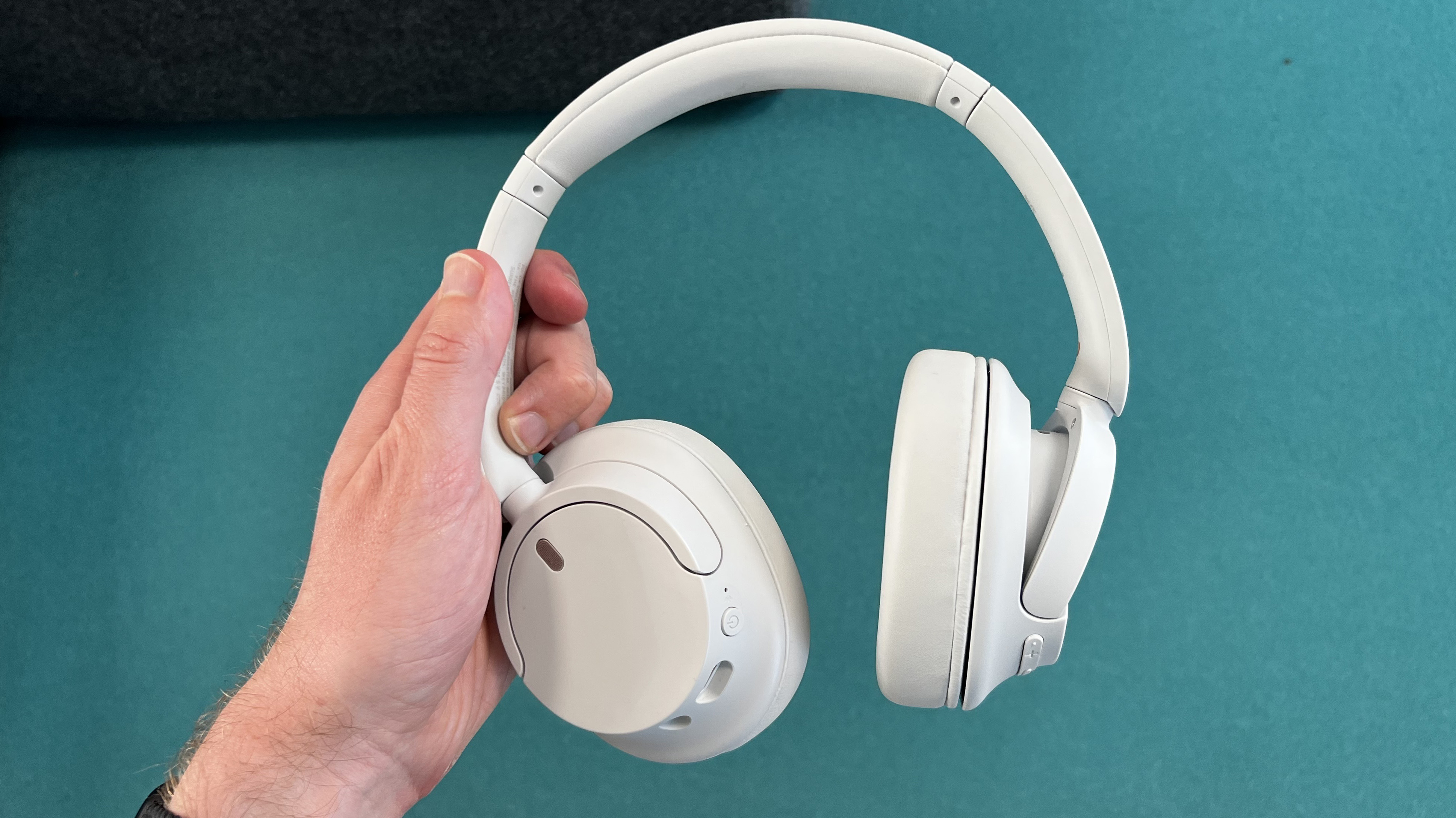 Sony WH-CH720N headphones held in one hand