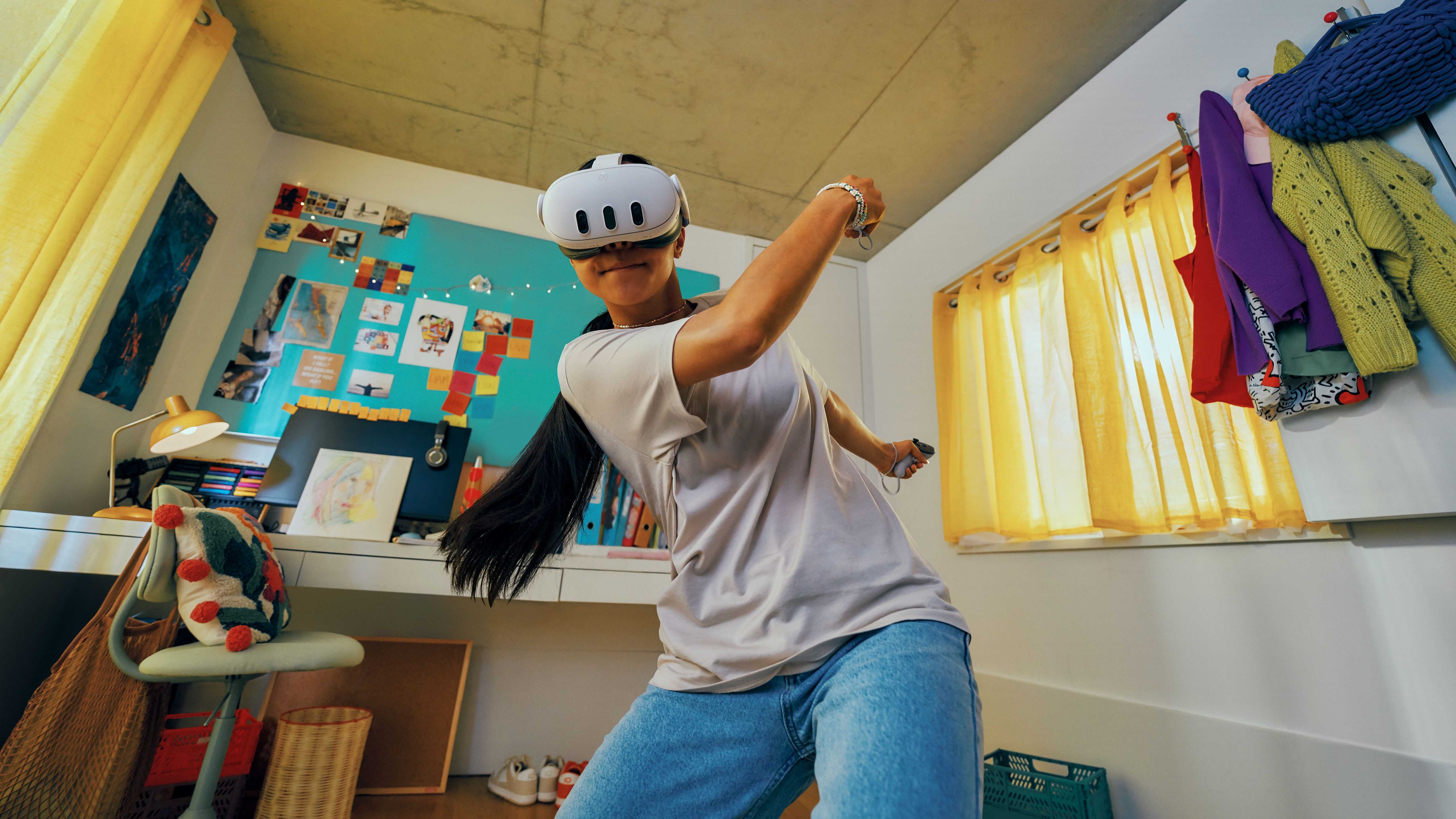 A Meta Quest 3 playing tennis in VR in their dorm room with their desk behind them.