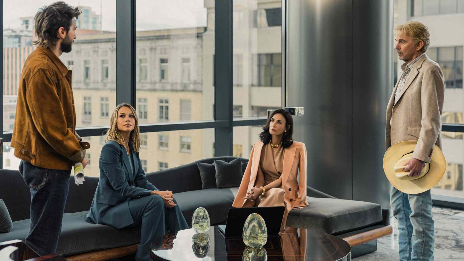 The cast of Landman in a boardroom