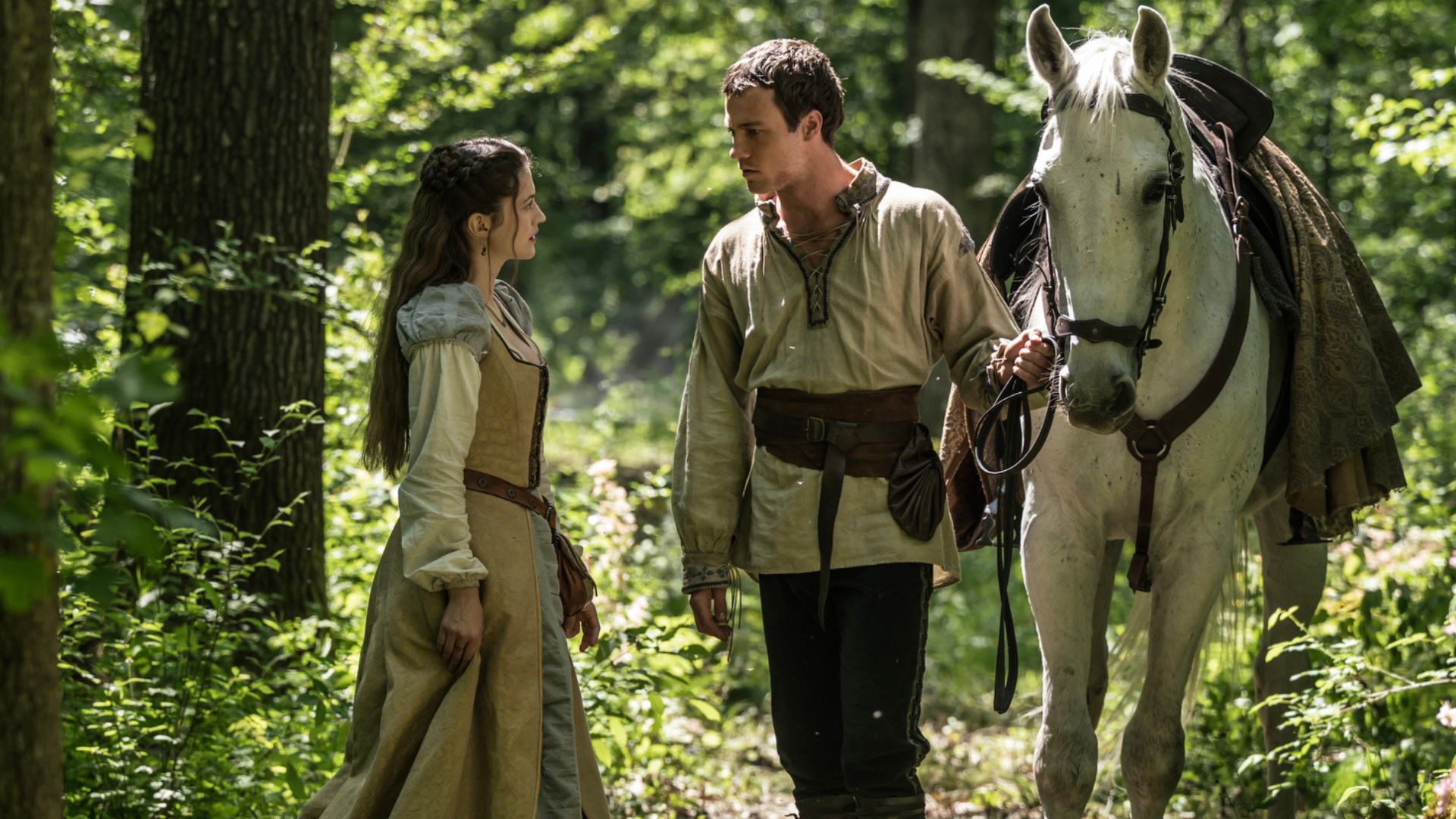Rob talks to Marian in the forest while holding the reins of a horse