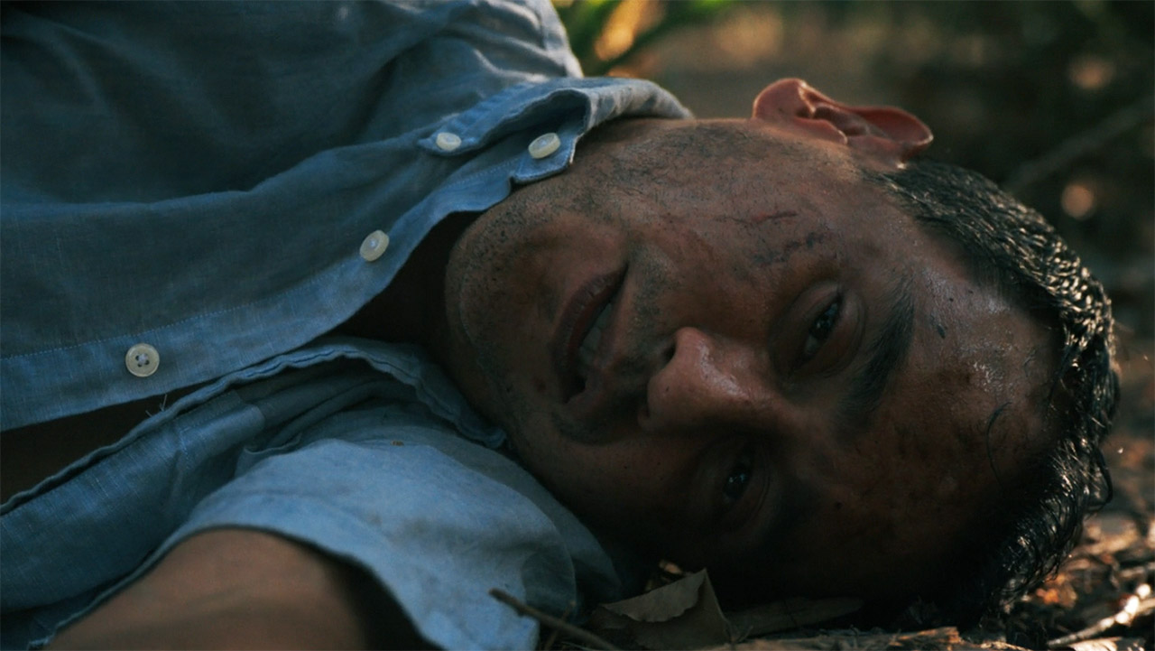 A near-dead Manousos lying on the rainforest floor in episode 7 of Pluribus