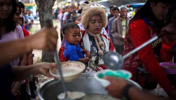 Displaced people queue for food at a school turned into a temporary shelter, amid clashes between Thailand and Cambodia along a disputed border area in Thailand's Surin province. -Reuters