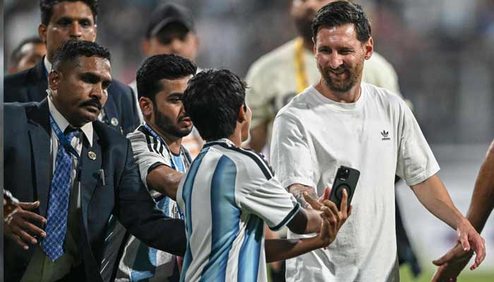 Argentine footballer Lionel Messi (right) interacts with a young fan during his Goat Tour at the Wankhede Stadium in Mumbai, December 14, 2025. — AFP