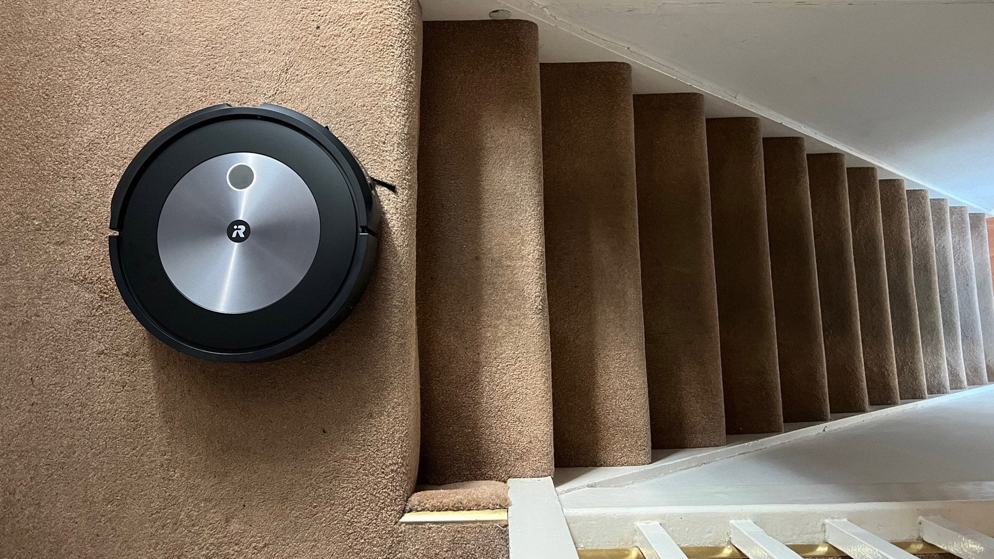The iRobot Roomba J7+ cleaning mat next to a staircase