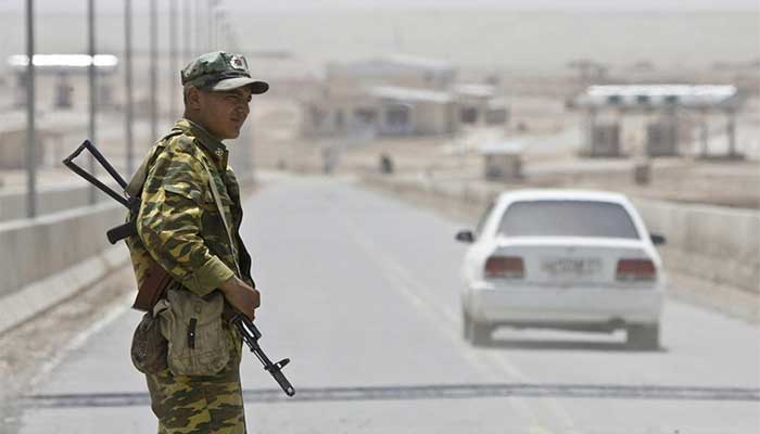 A border guard stands on a bridge into Afghanistan, crossing the Panj River, at the border outpost of Panji Poyon, south of Dushanbe, Tajikistan, May 31, 2008. — Reuters