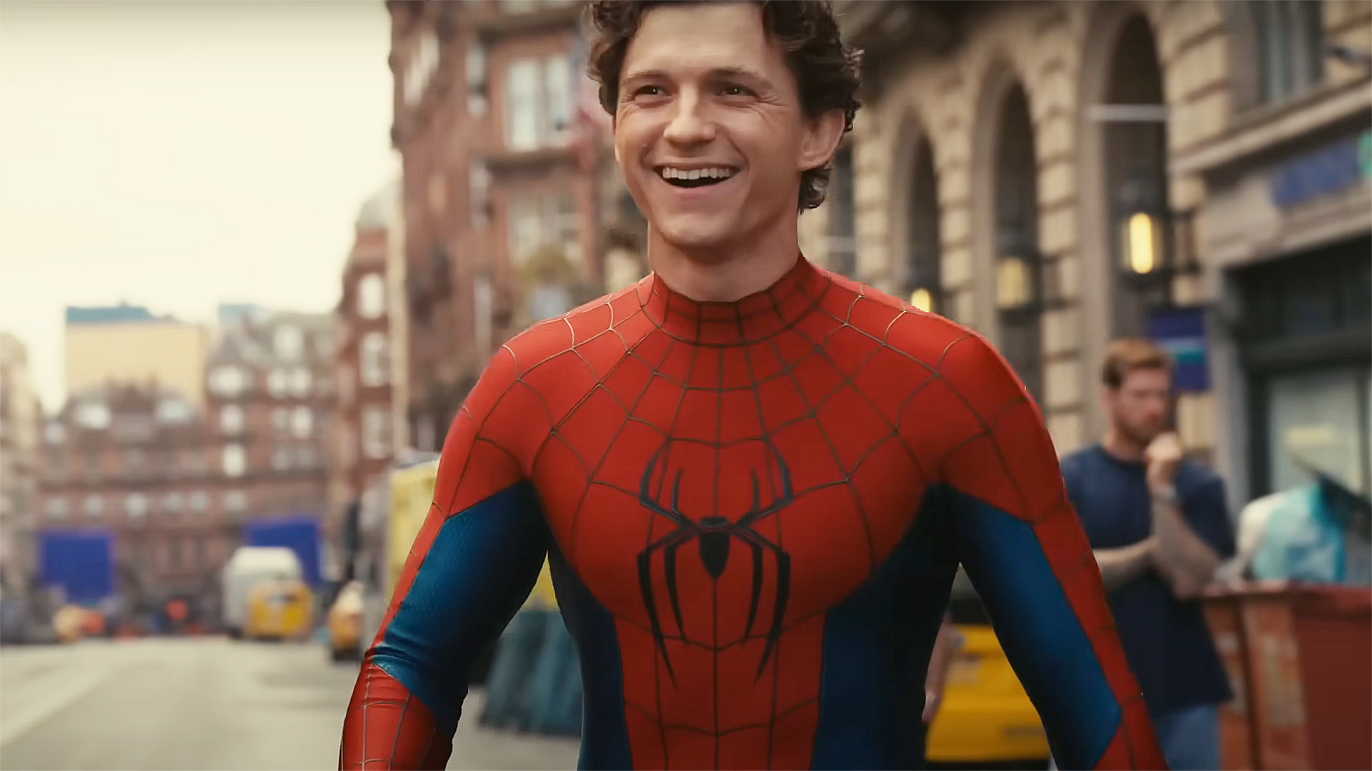 Tom Holland smiling and wearing his superhero costume in a behind-the-scenes video from Spider-Man: Brand New Day