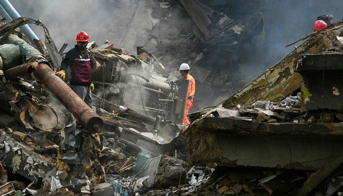 Rescuers search through debris after a massive fire at a shopping mall in Karachi, January 19, 2026. — AFP