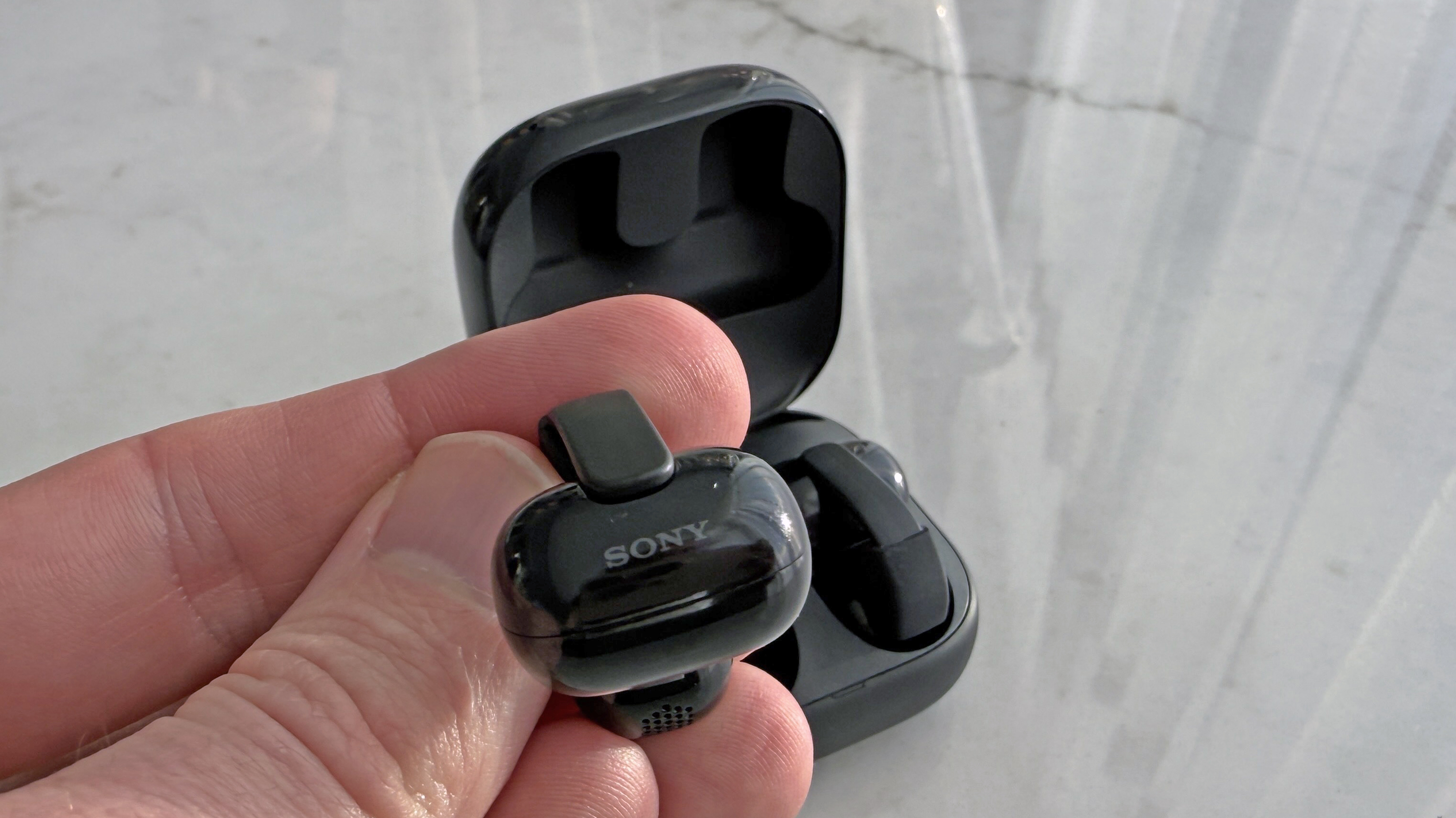 Sony LinkBuds clip in man's hand, showing Sony logo