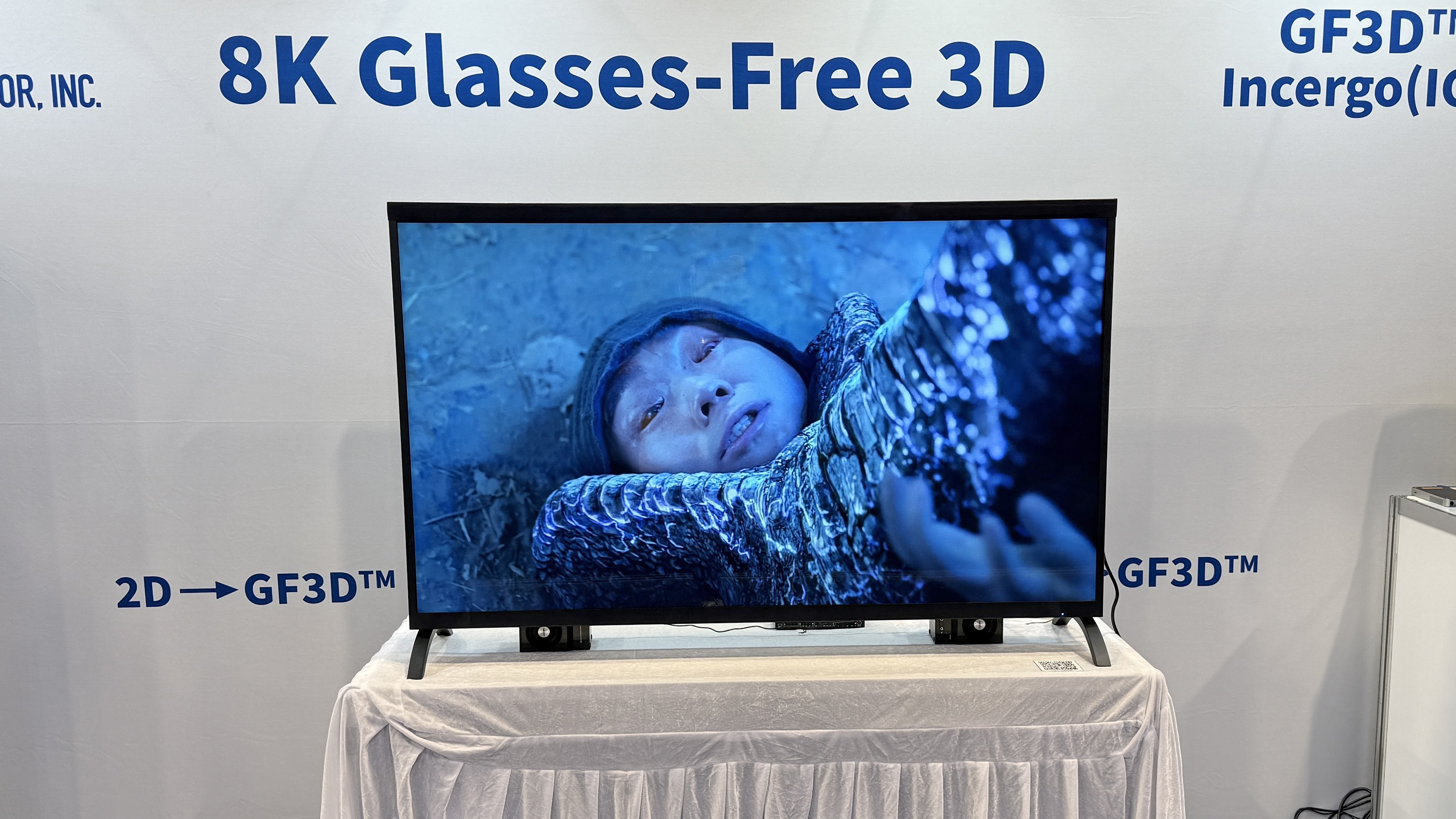 Visual Semiconductor's GF3D TV at CES 2026, showing a man trapped under a monster's foot on the screen