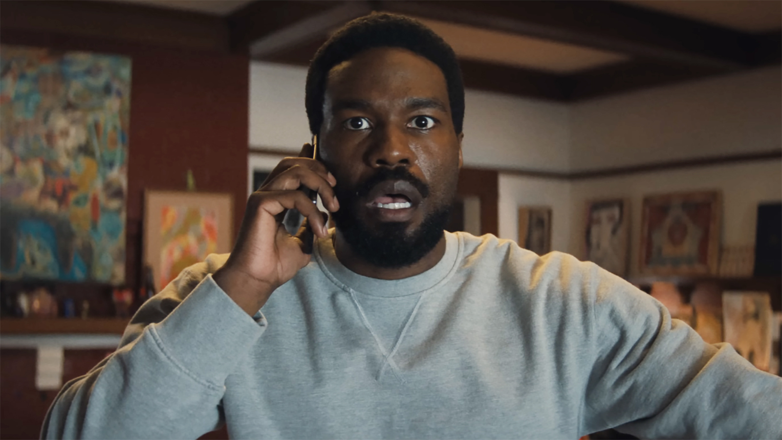 Simon Williams looks shocked as he listens to someone on a phone call in Marvel's Wonder Man