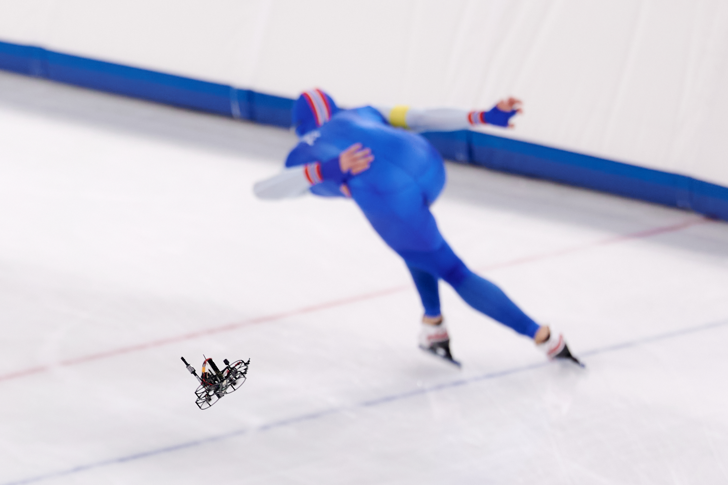 An FPV drone following a speed skater during the ISU Junior Speed ​​Skating World Cup in Milan, November 2025