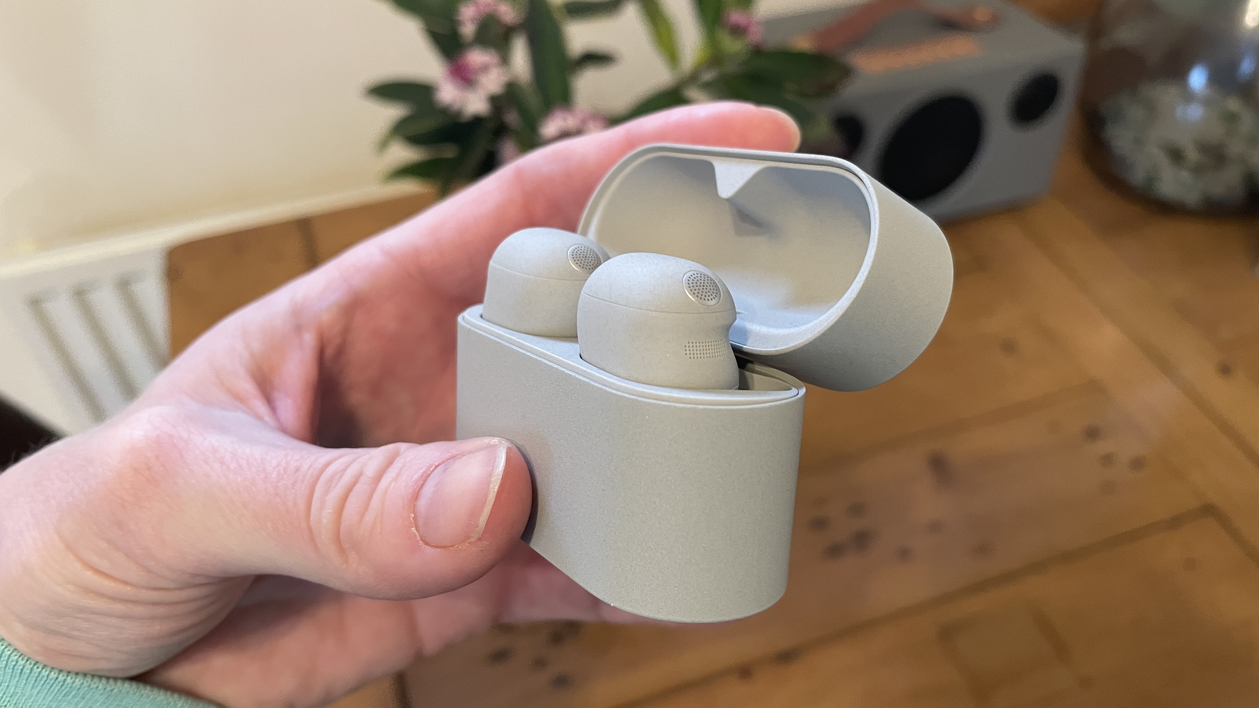 Sony WF-1000XM6 headphones next to the old generation. WF-1000XM5 and WF-C710N, on a colorful table