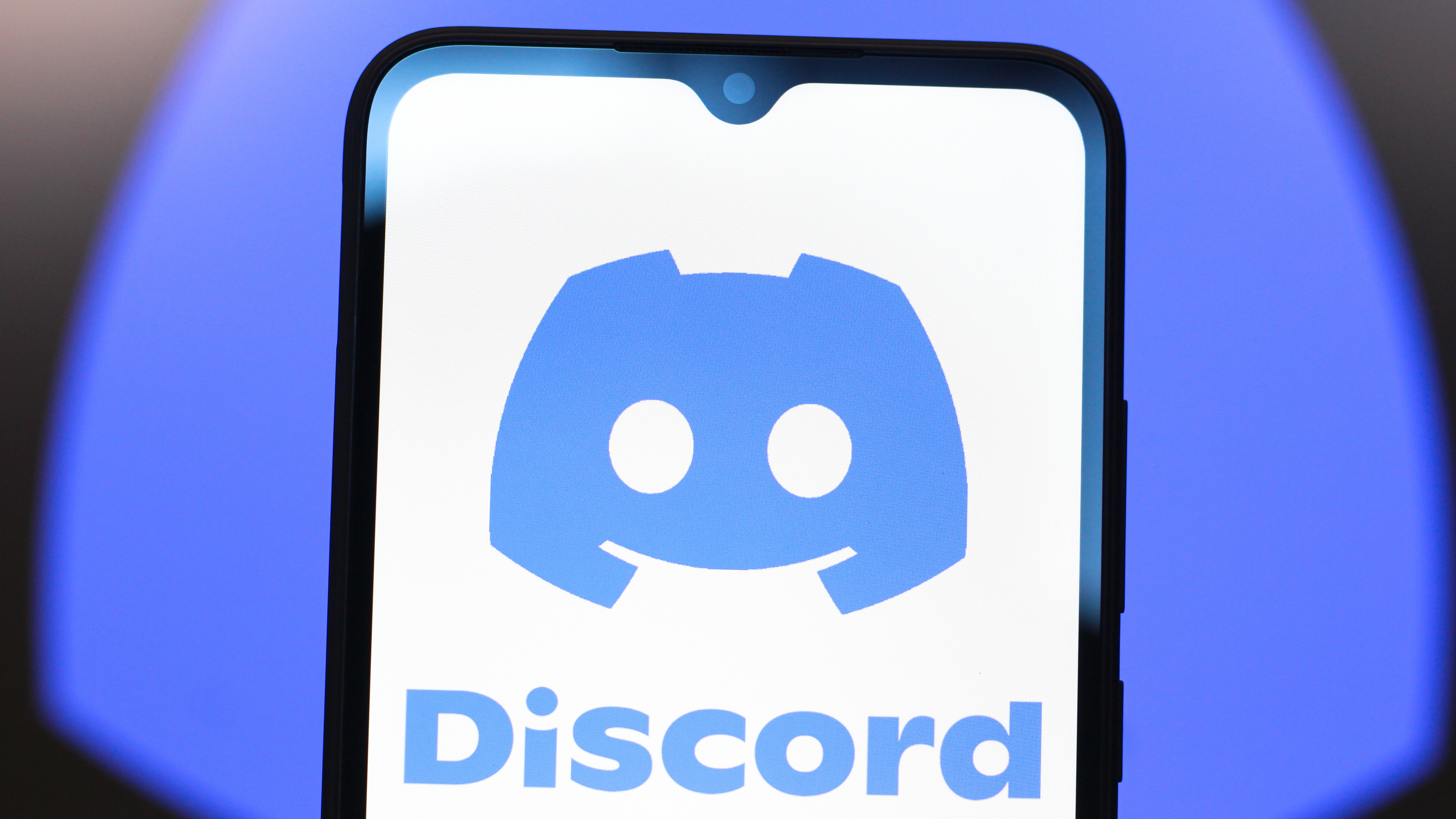 A phone displaying the Discord app and logo