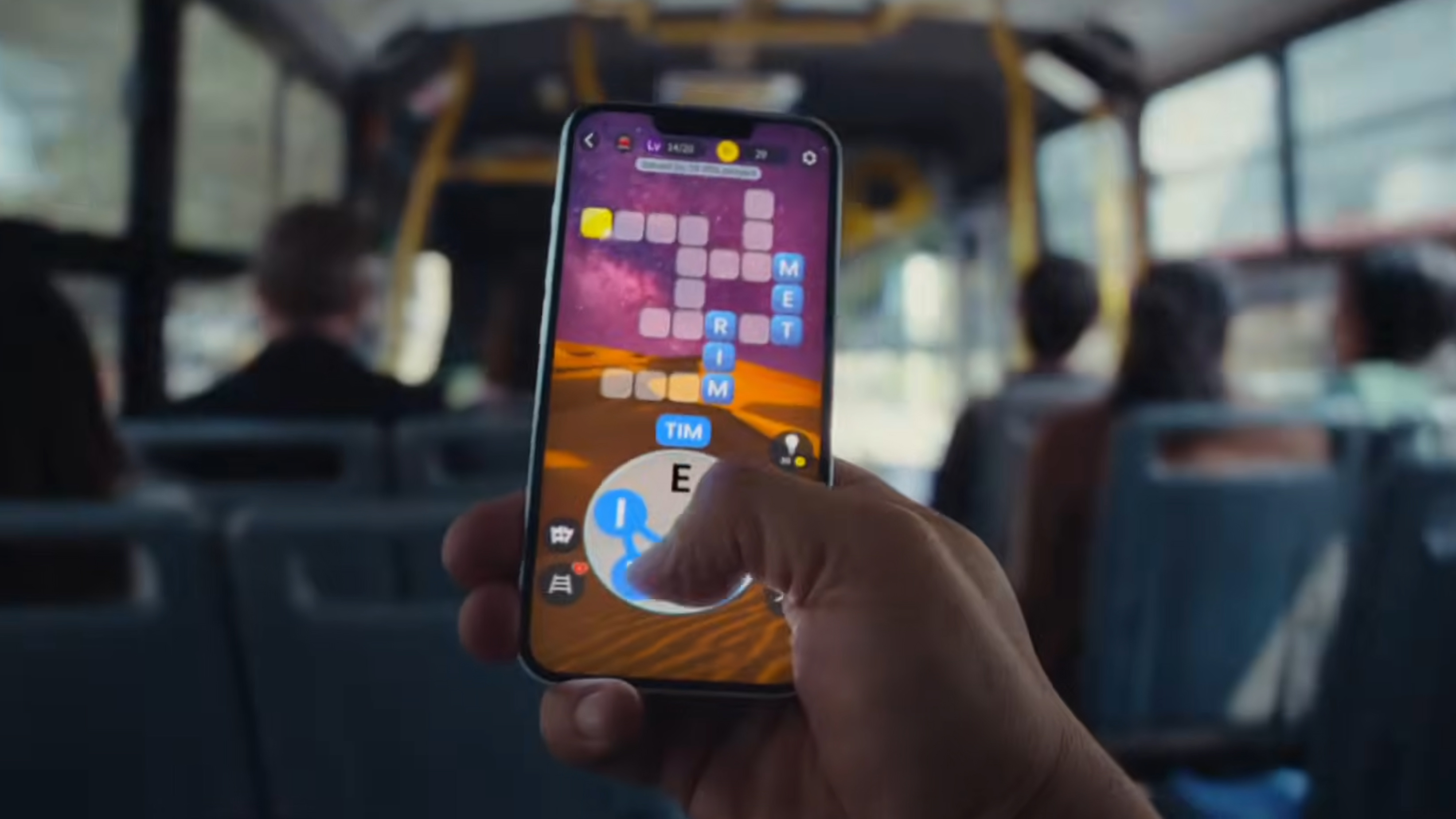 A hand holding iPhone 17e on a bus and playing a game