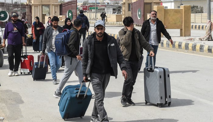 Pakistani nationals cross the Pakistan-Iran border after returning from Iran in Taftan in Balochistan province on March 2, 2026, following the death of Iranian Supreme Leader Ayatollah Ali Khamenei amid US-Israeli strikes. -AFP