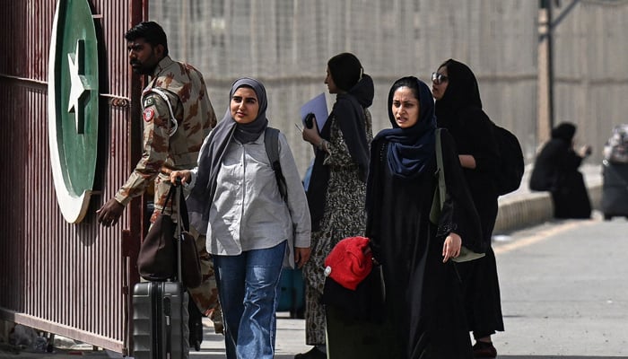 Pakistani nationals cross the Taftan border after returning from Iran, Balochistan province, March 2, 2026, amid ongoing US-Israeli strikes against Iran. -AFP
