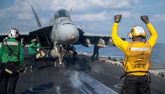 A US Navy sailor signals an F/A-18E Super Hornet on the flight deck of the Nimitz-class aircraft carrier USS Abraham Lincoln in support of the Operation Epic Fury attack on Iran at an undisclosed location March 4, 2026. — Reuters