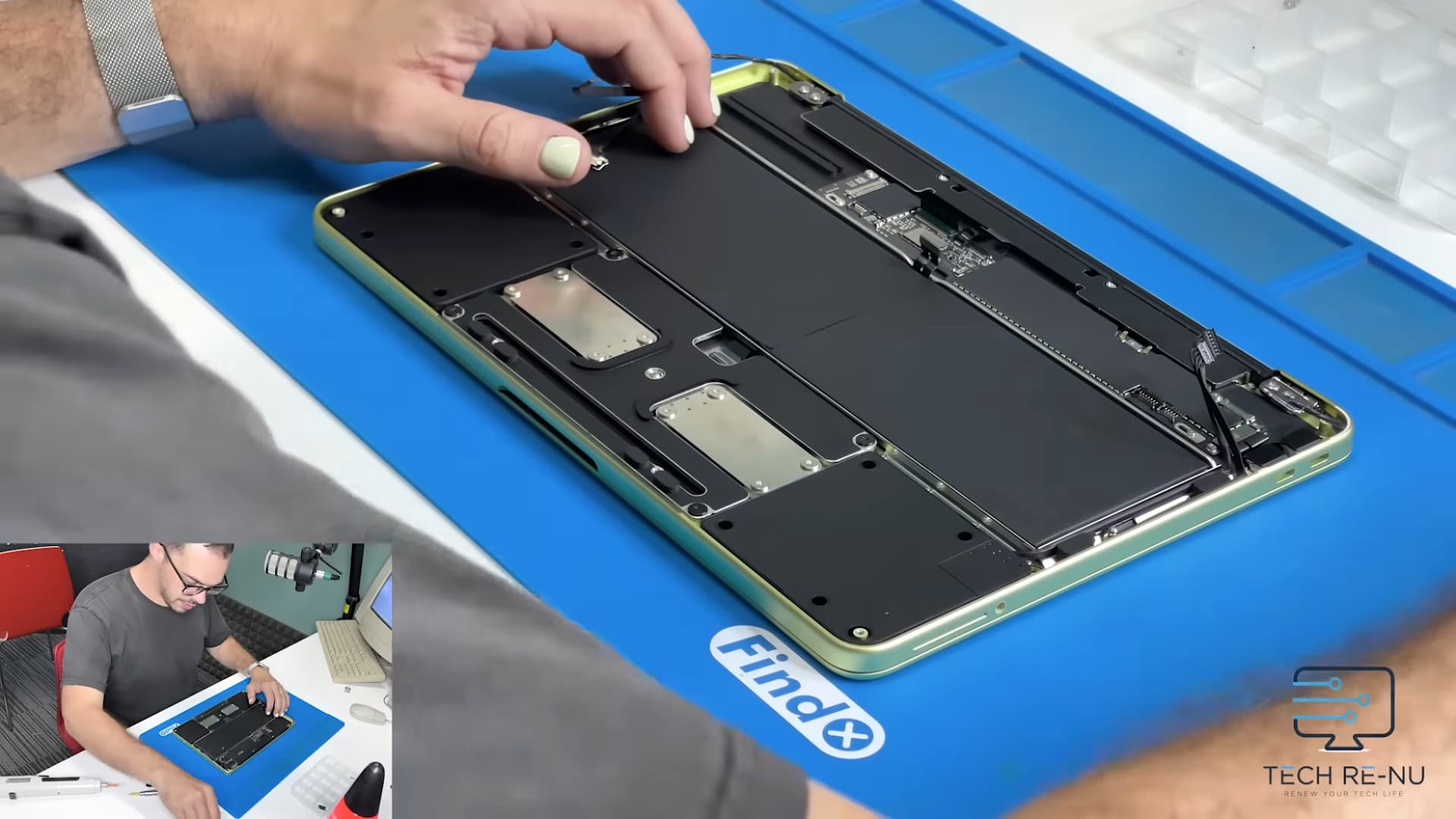 A person from the Tech Re-Nu repair company takes apart an Apple MacBook Neo laptop.
