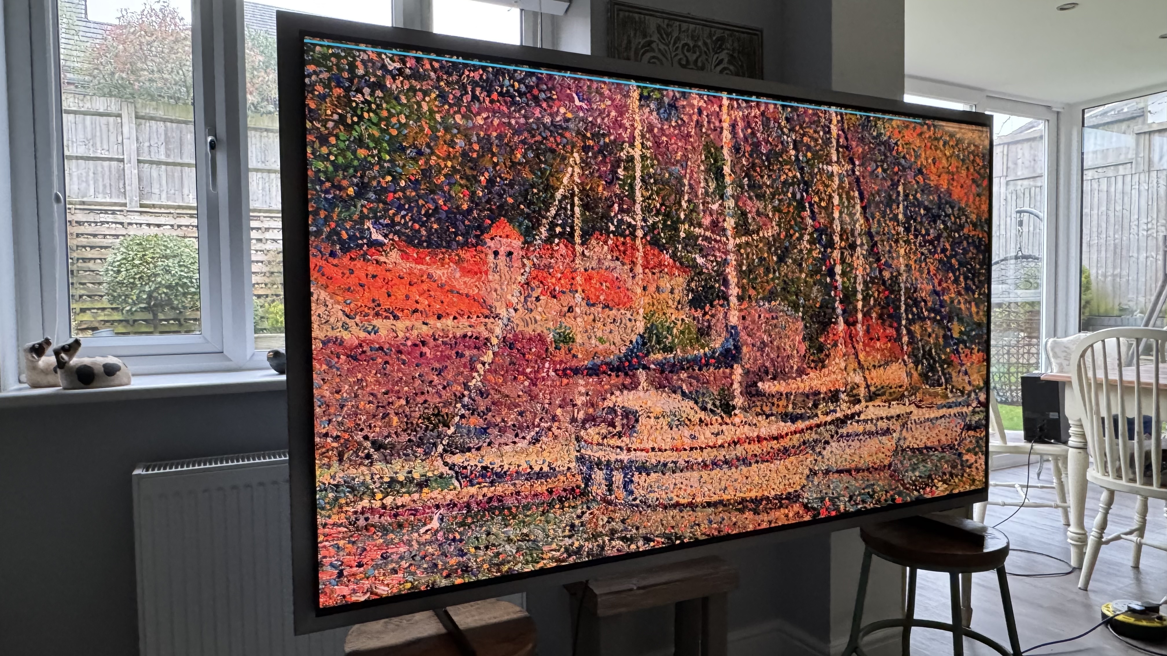 The Samsung S99H/S95H television in a house, showing on the screen an illustration of a boat in an impressionist style