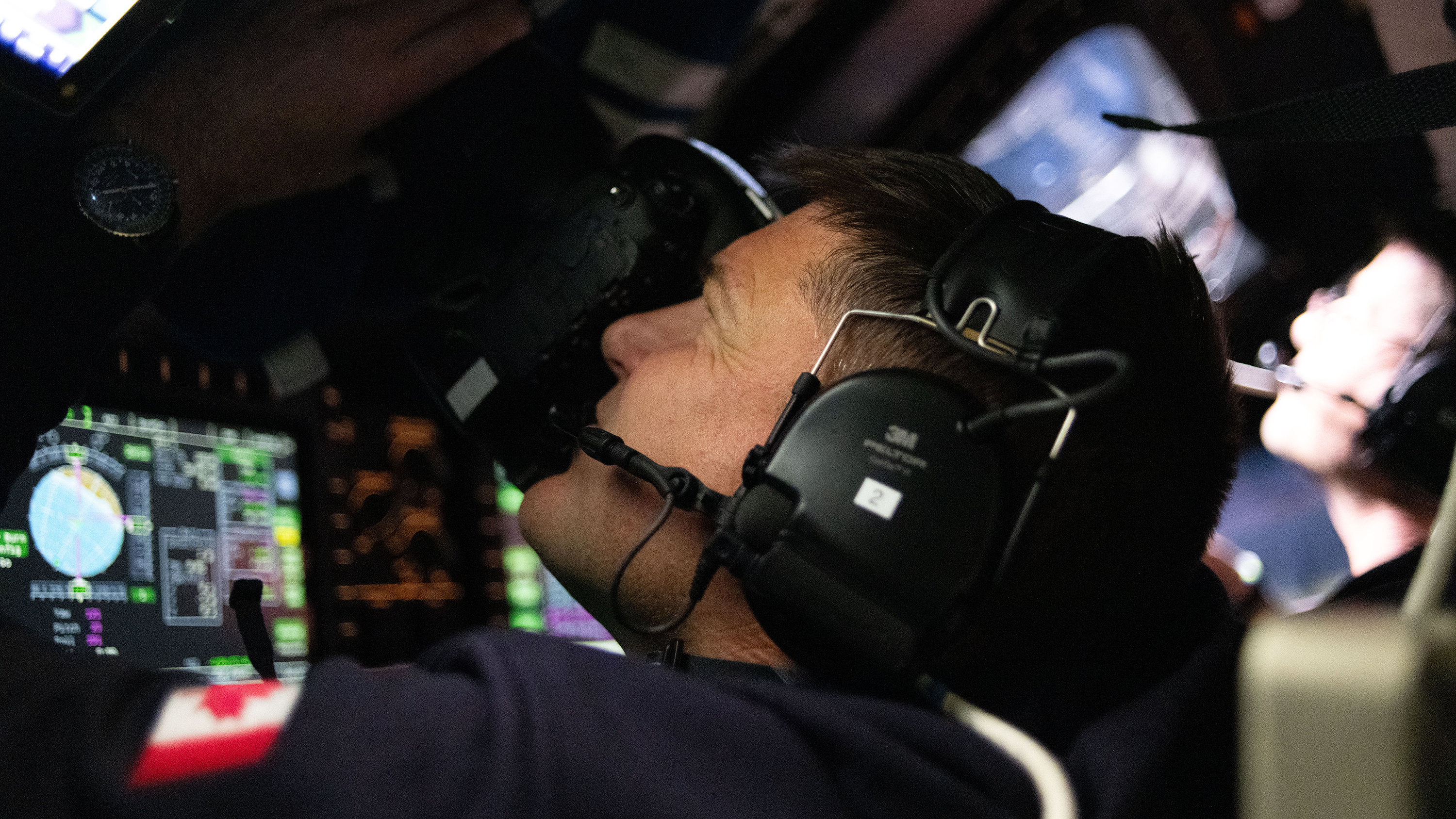 An Artemis II astronaut taking photos through the craft's window