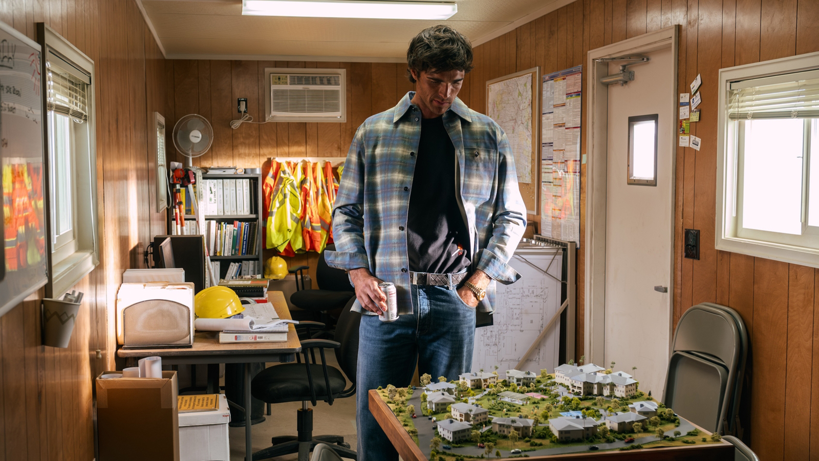 Nate looking at a model while holding a cup in Euphoria season 3