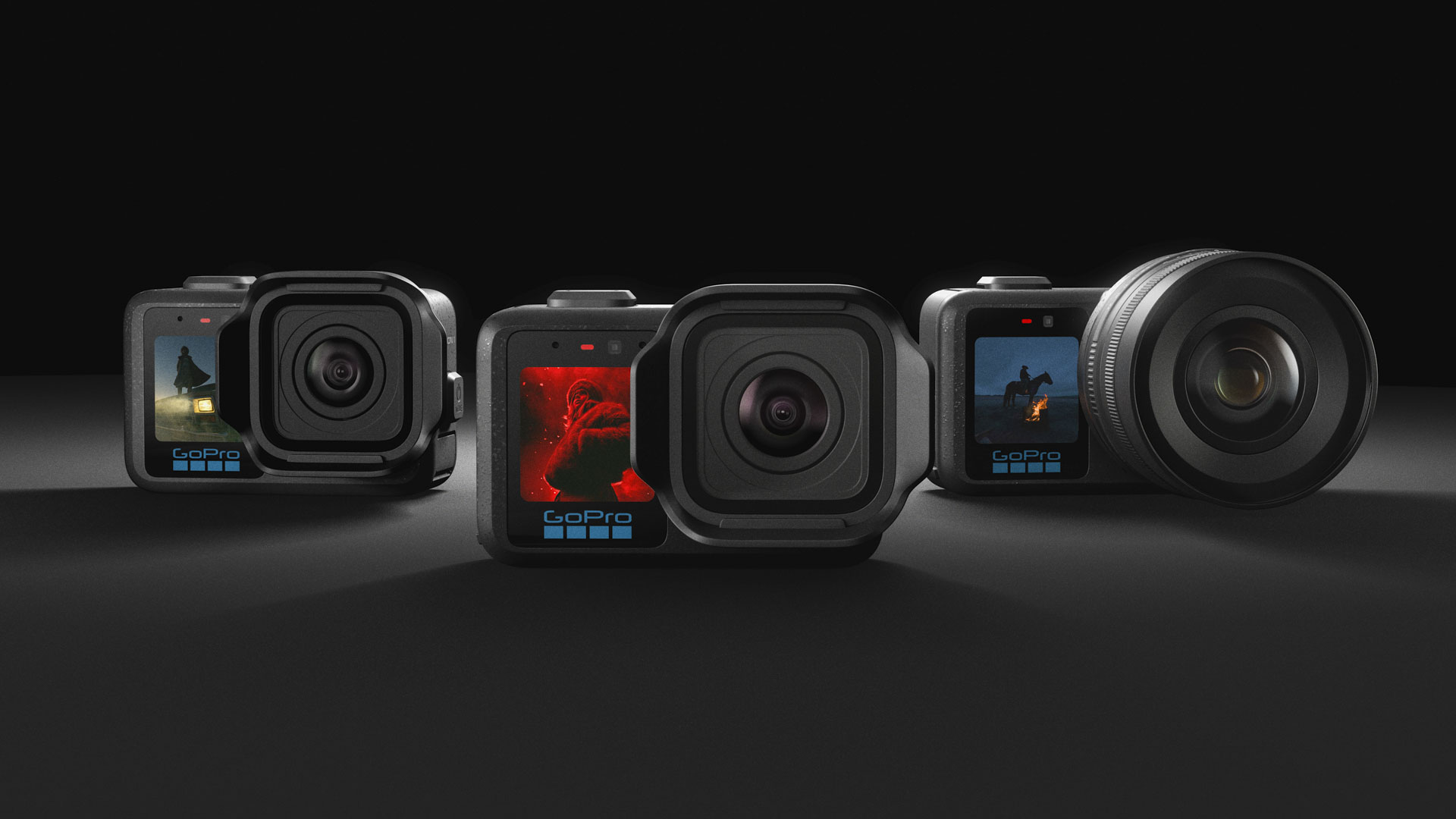 All three GoPro Mission 1 series action cameras side by side against a dark studio background