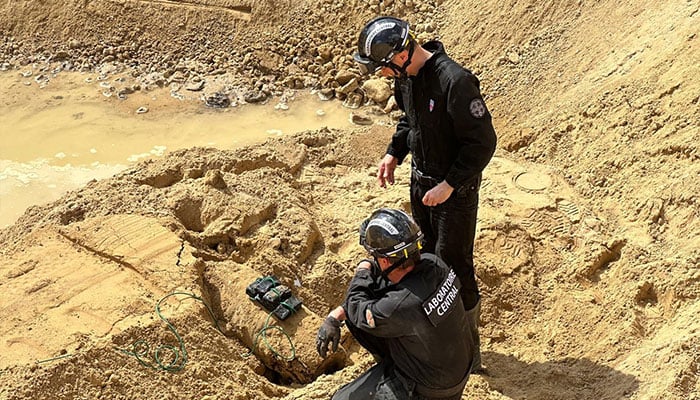 This undated photograph made available by the Police Prefecture on April 19, 2026 shows members of the police's Explosive Ordnance Disposal (EOD) unit operating to neutralize a World War II bomb partially discovered near a residential area in the northwest Paris suburb of Colombes. -AFP