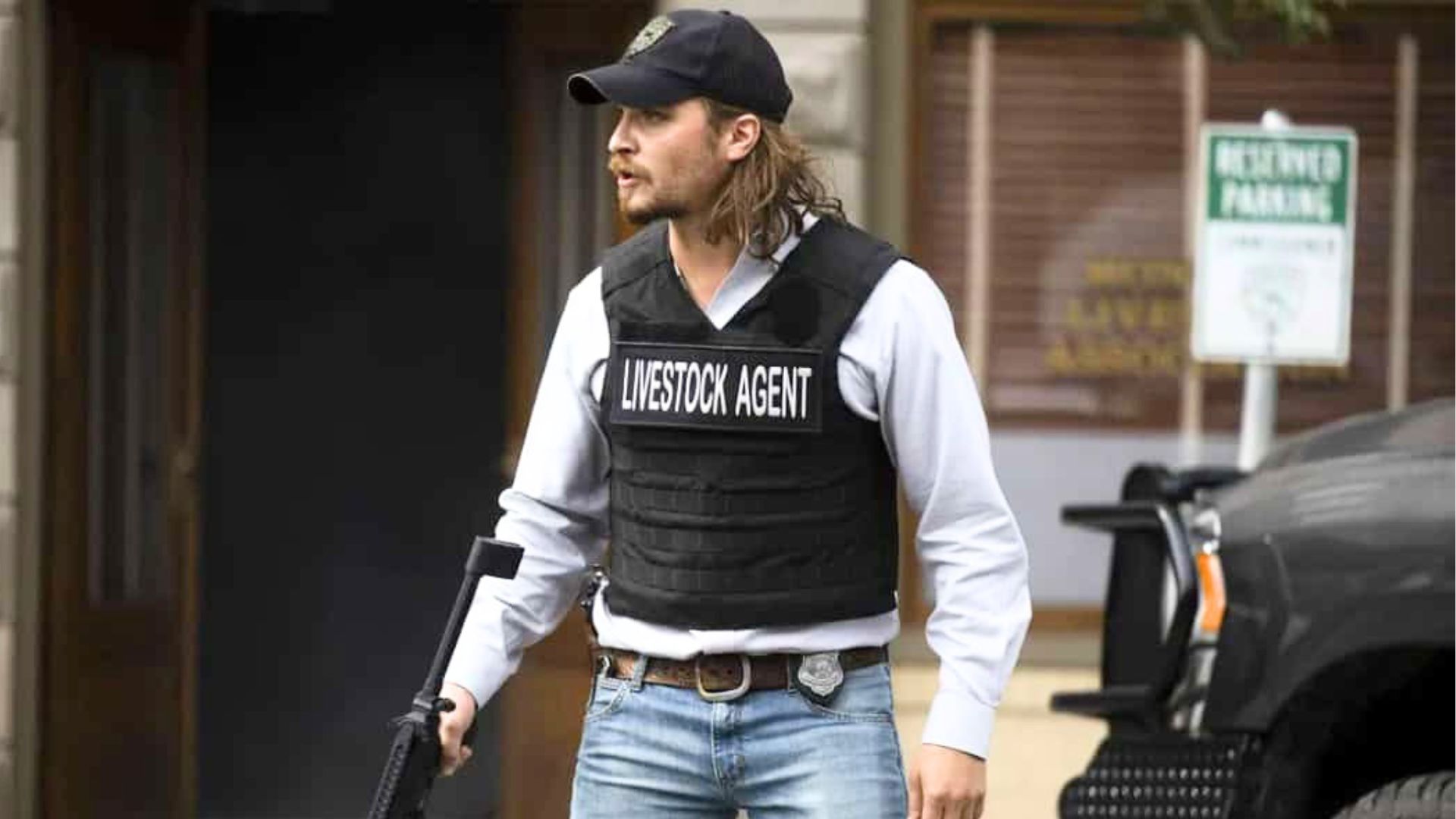 Kayce Dutton wears a livestock officer vest while carrying a gun